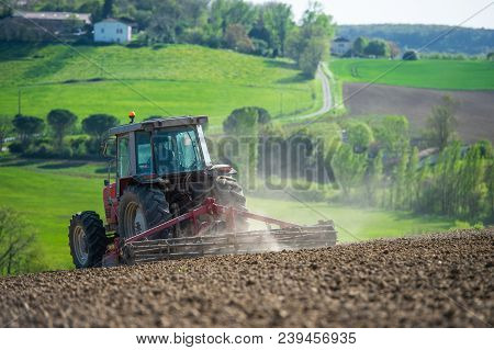 Tractor Plowing Field And Beautiful Landscape, France