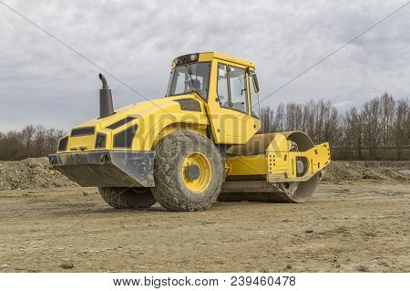 Yellow Road Roller At A Loamy Construction Site