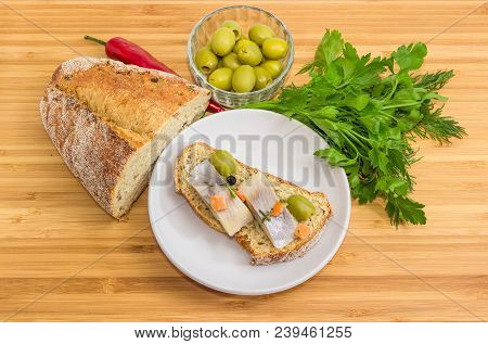 Open Sandwich Made Of Brown Sprouted Bread, Slices Of Fillet Of Pickled Atlantic Herring And Green O