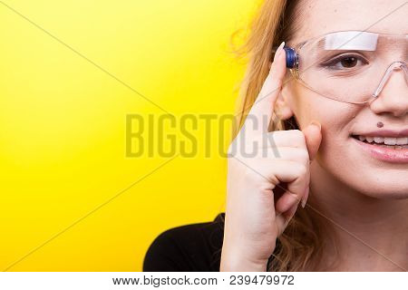 Woman With Futuristic Smart Glasses On Her Eyes On Yellow Background In Studio Photo