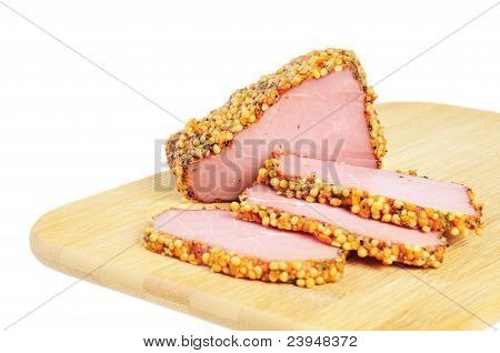 Kousek šunky s kořením na dřevěném prkénku