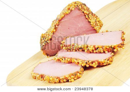 Kousek šunky s kořením na dřevěném prkénku