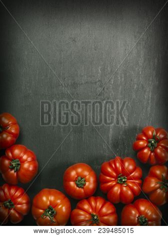 Photo Of A Table Top With Marmande Tomatoes Over A Slate Background.