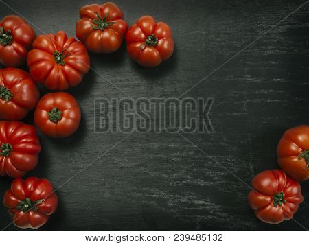 Photo Of A Table Top With Marmande Tomatoes Over A Slate Background.