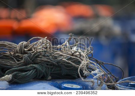 Fisherman Rope On Plastic Barrels With Orange Life Jackets In Background