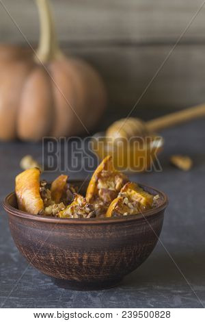 Authentic View Of The Baked Sliced Pumpkin With Honey And Walnuts In A Ceramic Bowl (pial) On A Dark