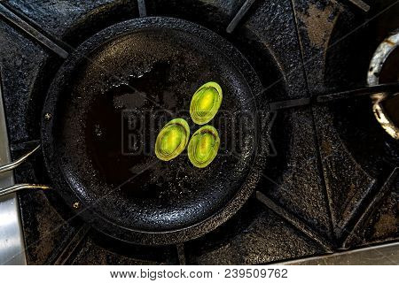 Close Up Small Round Slices Of Leek Roasted On Frying Pan For Cooking Salad