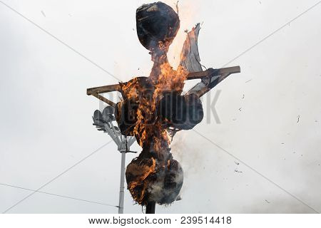 Burning Scarecrow On The Pagan Holiday Pancake Week, Against A Cloudy Winter Sky