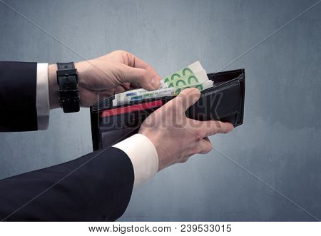 Businessman's hand in suit takes out eruo from his wallet