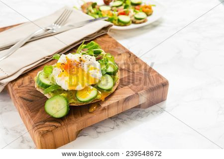 Raw Healthy Burger With Avocado Dressing, Cucumbers, Poached Egg And Multigrain Bread. Superfood Sna