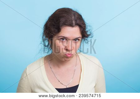 Portrait Of Young Angry Woman On Blue Background.