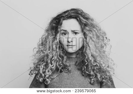 Photo Of Displeased Unhappy Young Woman With Curly Bushy Blonde Hair, Frowns Face In Bewilderment, W
