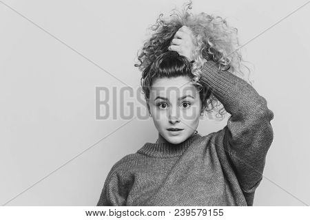 Indoor Shot Of Beautiful Blue Eyed Female In Red Sweater, Poses With Stunned Expression, Dressed In 