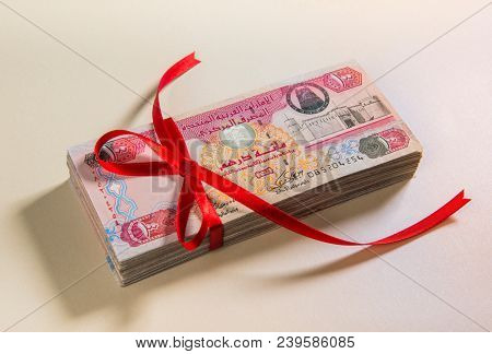 UAE Dhs currency notes with gift ribbon. A conceptual image for cash donation, charity, reward or gift.