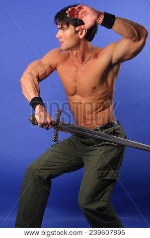 The Sexy Warrior Holds A Sword As He Prepares For Battle.