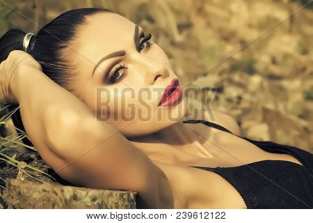 Closeup Photo Of Beautiful Seductive Brunette With Ponytail And Bright Makeup In Black Lingerie Lyin