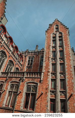 Brick Facade Of Buildings In Typical Flanders Style And Blue Sky At Bruges. With Many Canals And Old