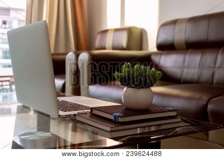 Interior Of Home Office Space During Sunset With Laptop On Table.