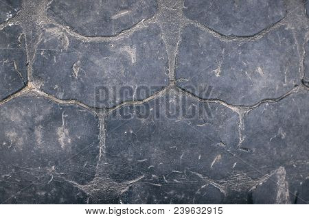 Old Car Tire Tread Texture Background. Worn Out Protector Of Car Tire. Used Wheels Close Up.