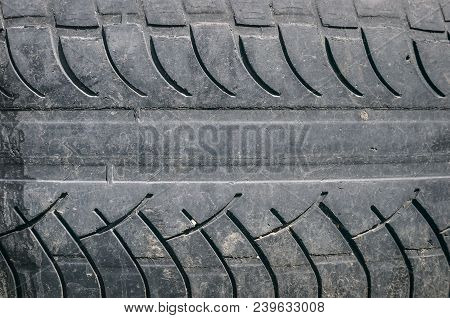 Old Car Tire Tread Texture Background. Worn Out Protector Of Car Tire. Used Wheels Close Up.