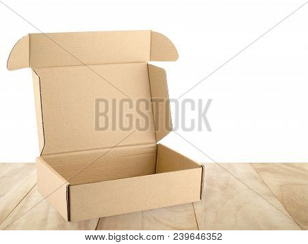 open empty flap brown beige carton box on wooden table counter isolated on white background, close up single cardboard parcel box for packages delivery, recyclable paper packaging