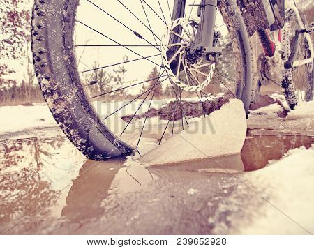 Bike Drowned In Muddy Pool Within Winter Trip. Broken Pieces Of Ice Around Freeze Terain Tyre, Wide 