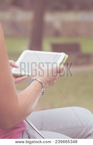 Detail Of A Woman Using Tablet In The Park.