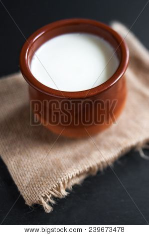 Sour  Cream Or Natural  Cottage Cheese Curd In Clay Pot On Dark  Background. Traditional Cuajada Yog
