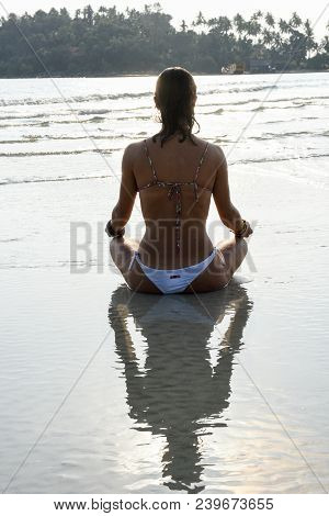 Girl Who Practices Yoga On The Beach