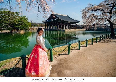 Young Asian Woman Traveler In Korean National Dress Or Hanbok Traveling Into The Gyeongbokgung Palac