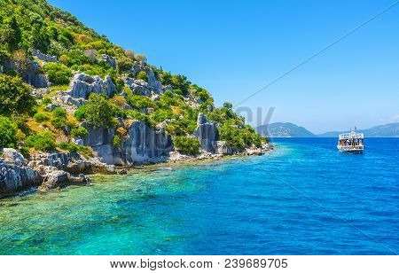 The Pleasure Boat Floats Along The Coast Of Kekova Island Next To The Ruins Of Sunken Lycian Settlem