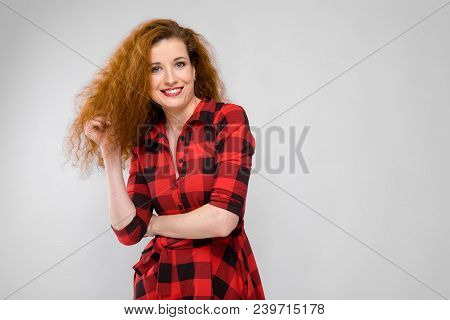 Charming Young Girl In A Checkered Cloth On A Gray Background