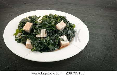 Cooked Wakame Seaweed Salad In White Bowl On Natural Stone Background. Healthy Algae Food With Soy S