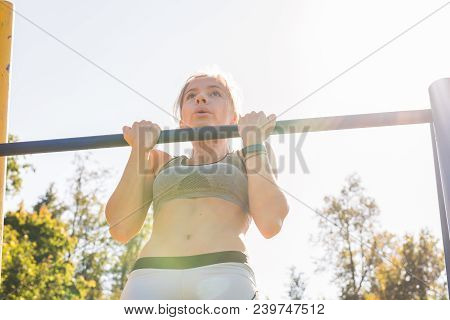 Fit Woman Doing Pull-ups. Young Athletic Fitness Woman Working Out At Outdoor Gym Doing Pull Ups At 