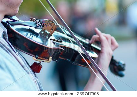 The Violin Is Big, Against The Backdrop Of The Street