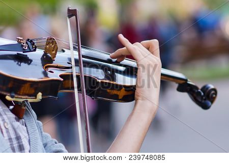 The Violin Is Big, Against The Backdrop Of The Street