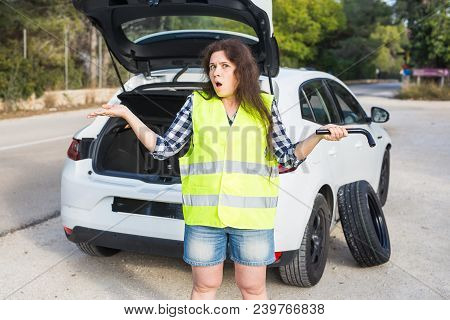 Broken Down Car With Warning Triangle. Woman Standing Alongside Her Broken Down Car On The Road And 