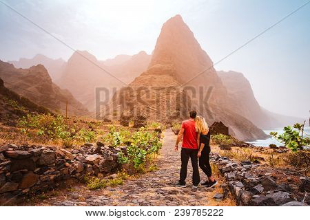 Tourist Couple In Aranhas Valley Hiking From Cruzina To Ponta Do Sol. Huge Mountains Of Coastline An