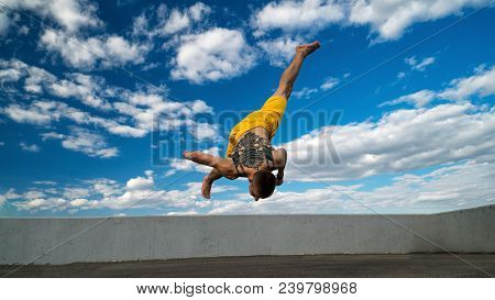 Tricking On The Street. Martial Arts. The Guy Performs The Jump Barefoot. Shooted From The Bottom Fo