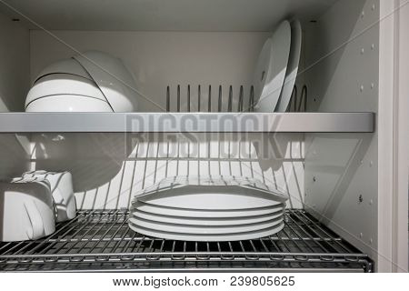 White Porcelain Dishes Dried On Metal Dish Rack. Way To Organize Kitchen And Minimize Space With Mod