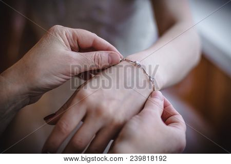 Woman's Hand Wearing Braslet To The Hand Of Bride