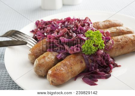 Delicious German Thuringer Sausage With Spiced Red Cabbage On A White Plate.
