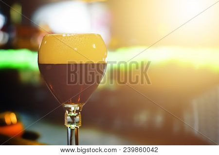 Glass Of Fresh Dark Beer On Rustic Pub Background. The Belgian-style Dubbel Ranges From Brown To Ver