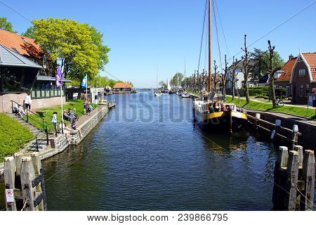Medemblik, The Netherlands - May 6, 2018: Unknown Tourists Sitting And Standing In The Historic Dutc