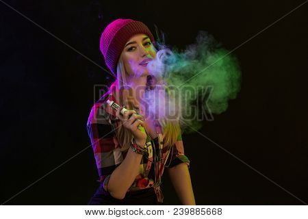 Vaping Girl. Young Hipster Woman Vape E-cig On Black Background. Hip-hop Style. Vapor Concept. Vapin