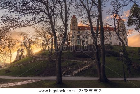 Bratislava Castle Or Bratislavsky Hrad Through The Trees At Sunset. The Main Castle Of Capital City 