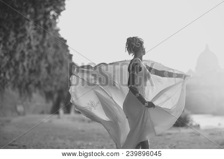 Back View Of Pretty Lovely Blond Bride In Long White Wedding Dress With Train Spinning Outdoor Sunny