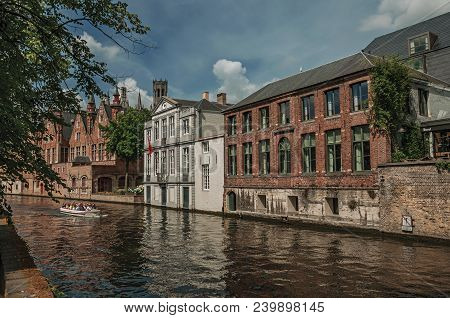 Bruges, Belgium - July 05, 2017. Boat And Brick Buildings On The Canal Edge At Bruges. With Many Can