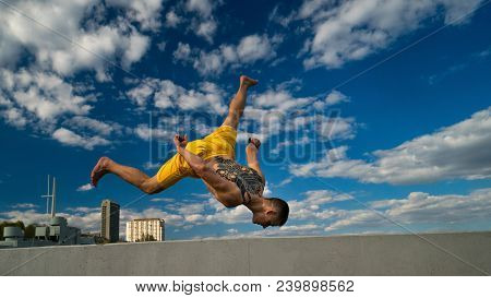 Tricking On The Street. Martial Arts. Guy Performs Blow Barefoot. Shooted From Bottom Foreshortening