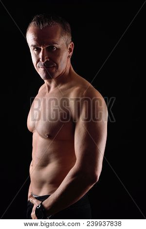Portrait Of A Man With Naked Torso On Black Background